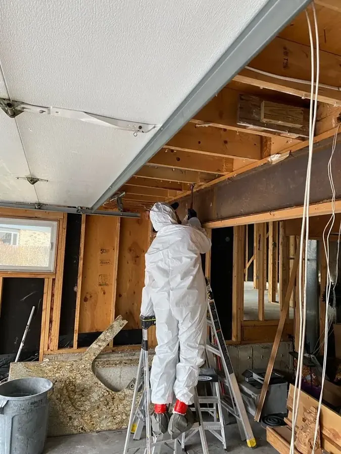 Technician removing water-damaged framing after a burst rim-joist pipe in Lexington, MN