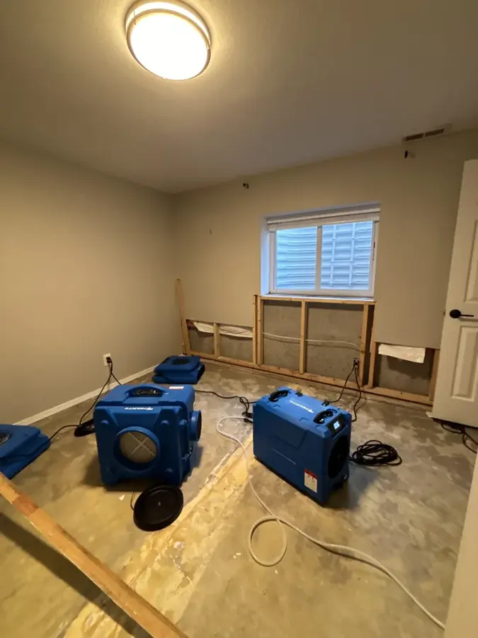 Blue air movers drying a flood-cut Circle Pines bedroom
